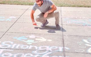 a participant at chalk the walk writing an inspiring message